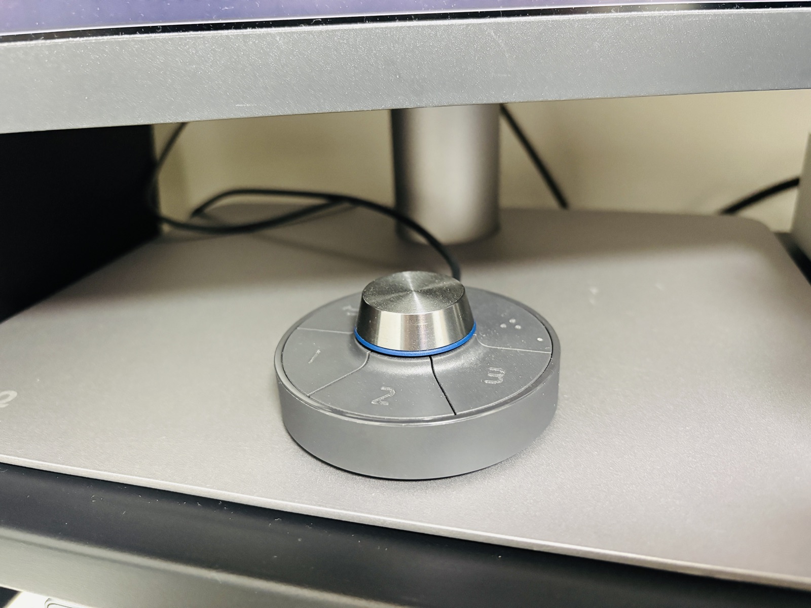 BenQモニター付属のHotkey Puck（ダイヤル＋3ボタンの手元コントローラー）をモニター台座の上に置いた様子
